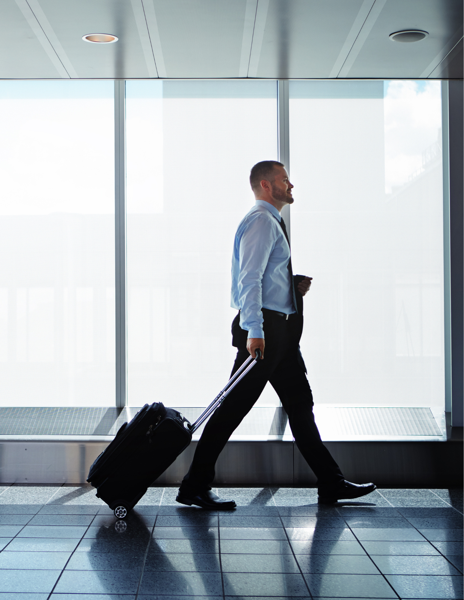 Business traveller walking through an airport with luggage